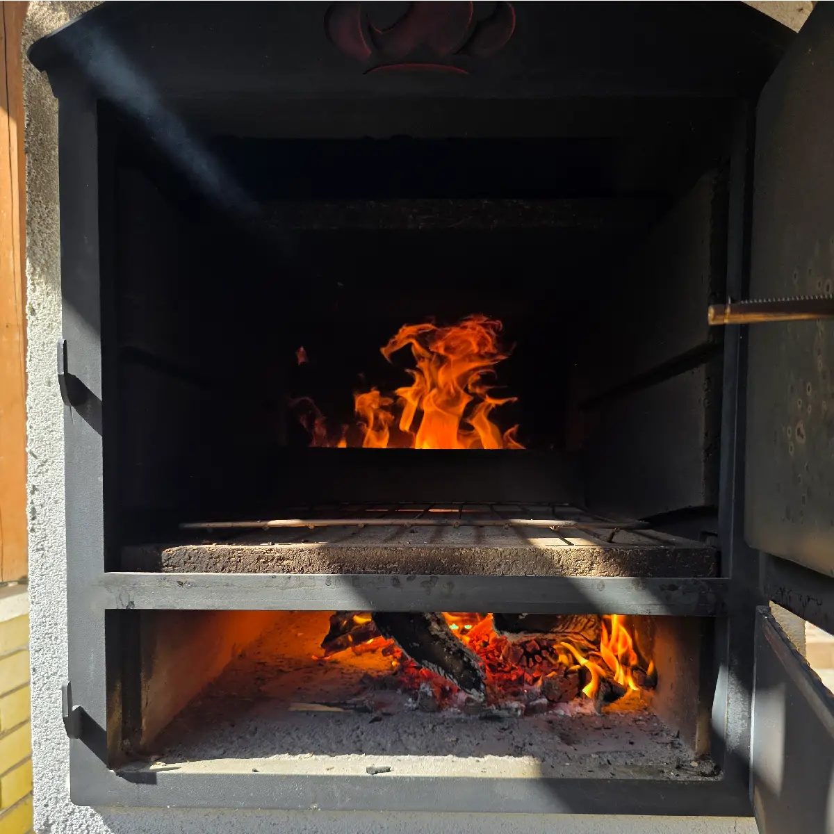 A living ember bed inside a Tynker oven creating stable baking heat