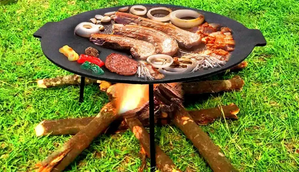 Bacon, onion, sausage, and vegetables cook together on the cast-iron disc
