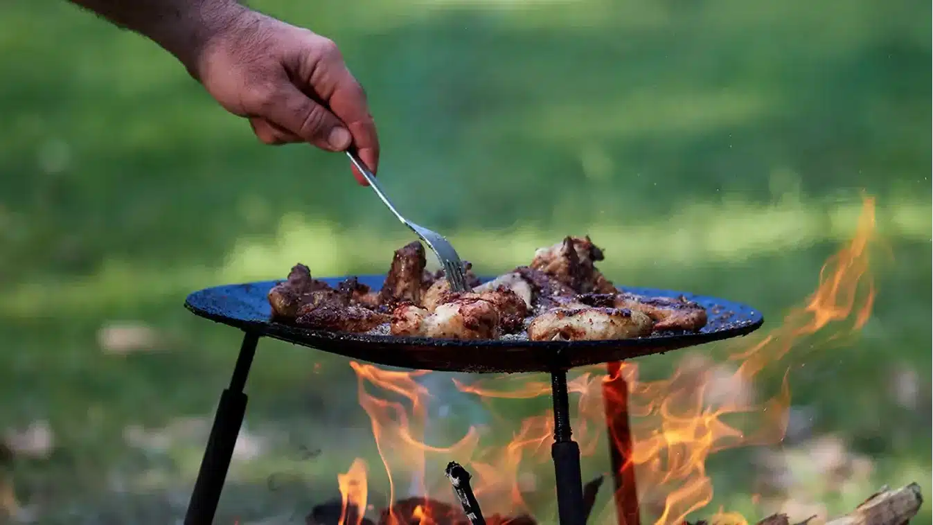 opekanie mäsa na grilovacom pláte nad otvoreným ohňom
