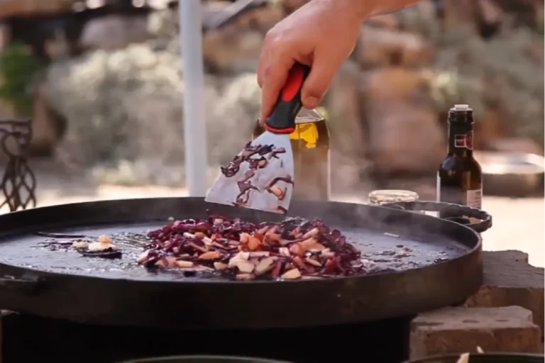 Pomaly pečené husacie stehno na jablkách s červenou kapustou na liatinovom pláte