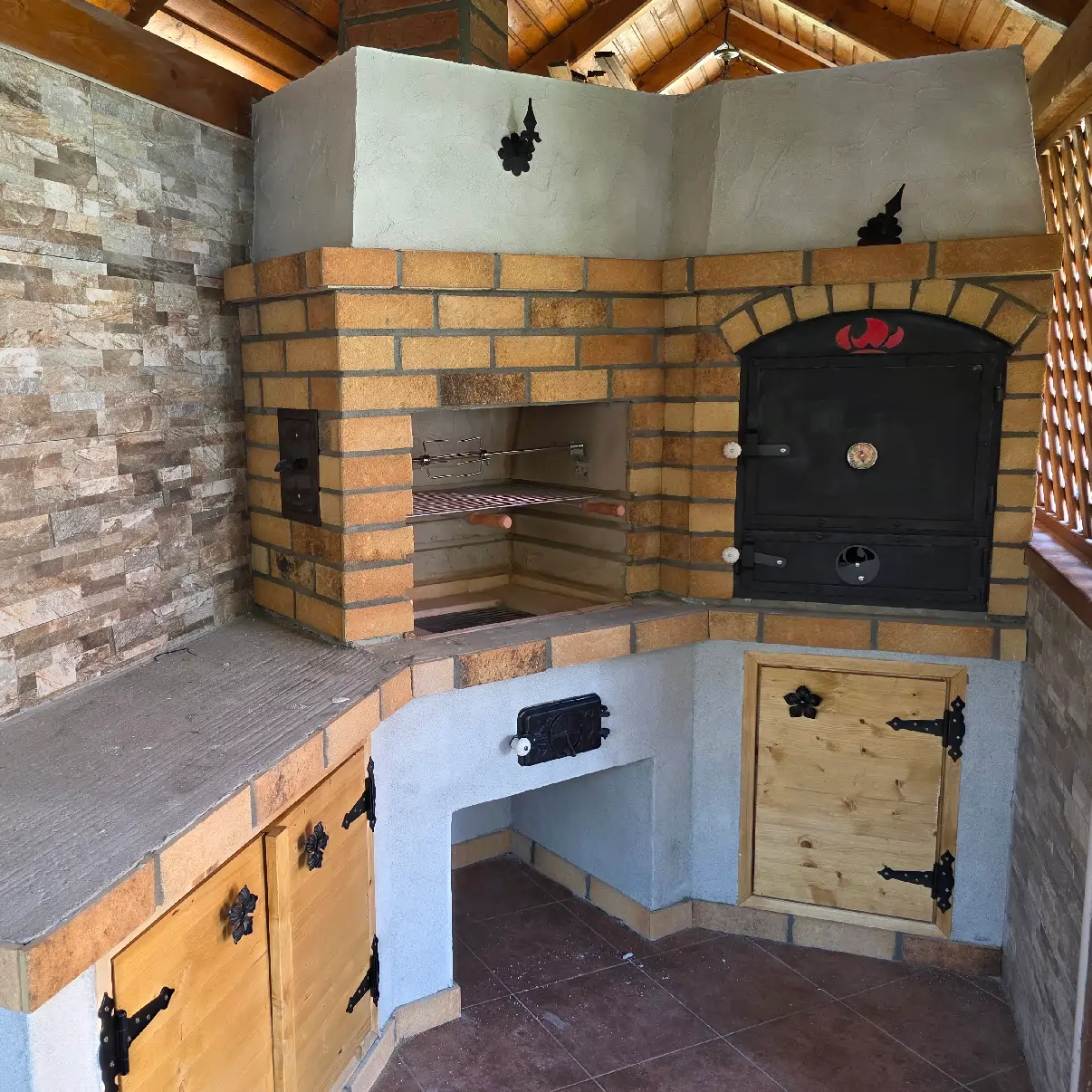 Built outdoor kitchen with a Tynker heat-storage wood-fired oven and grill, with good ventilation and stable placement